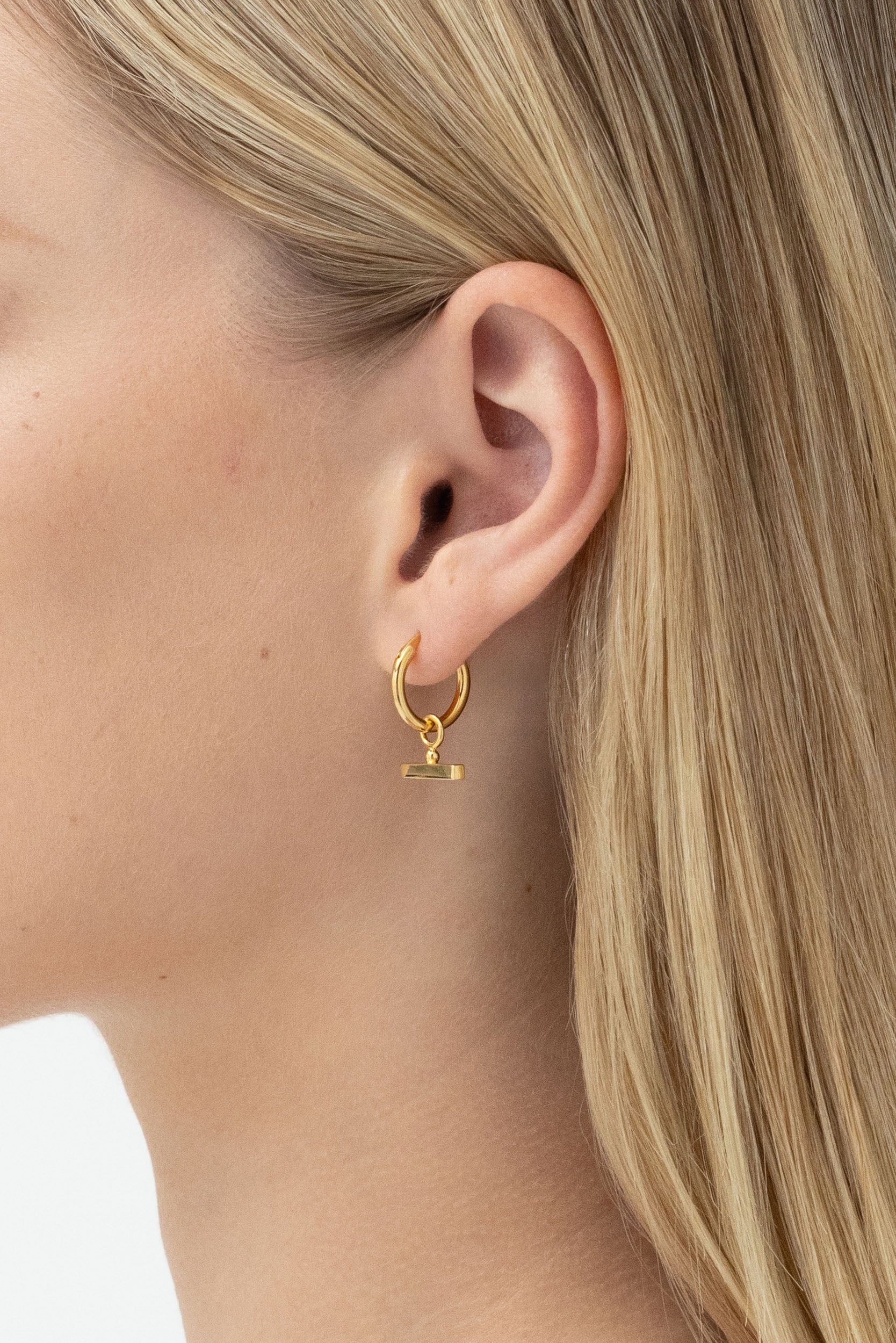Model's side profile displaying Chloe Sleeper Hoops in 14k gold vermeil.