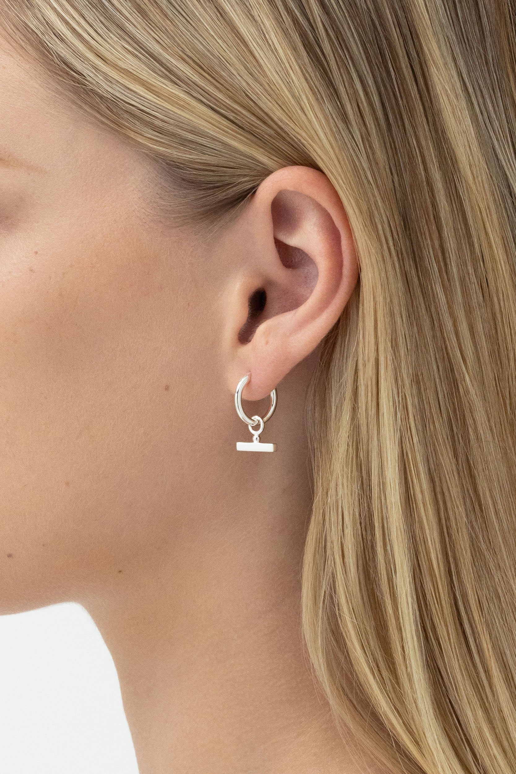 Model's side profile displaying Chloe Sleeper Hoops in Sterling Silver..
