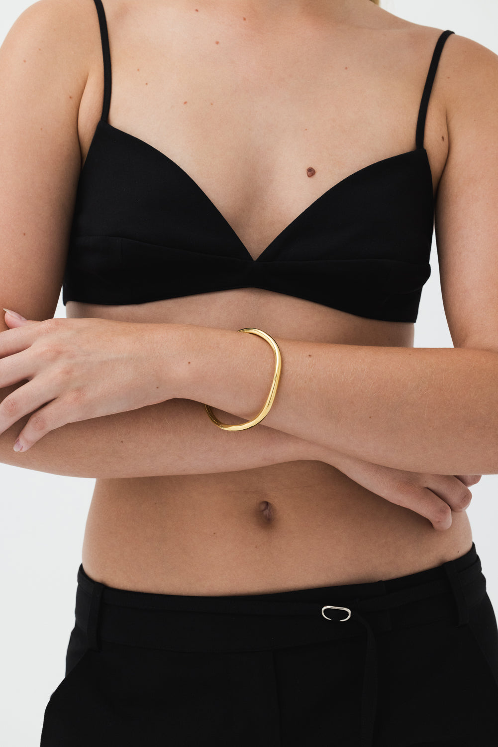 Model wearing Fundamental Bangle 14k Vermeil: Organic-shaped bracelet in recycled gold.